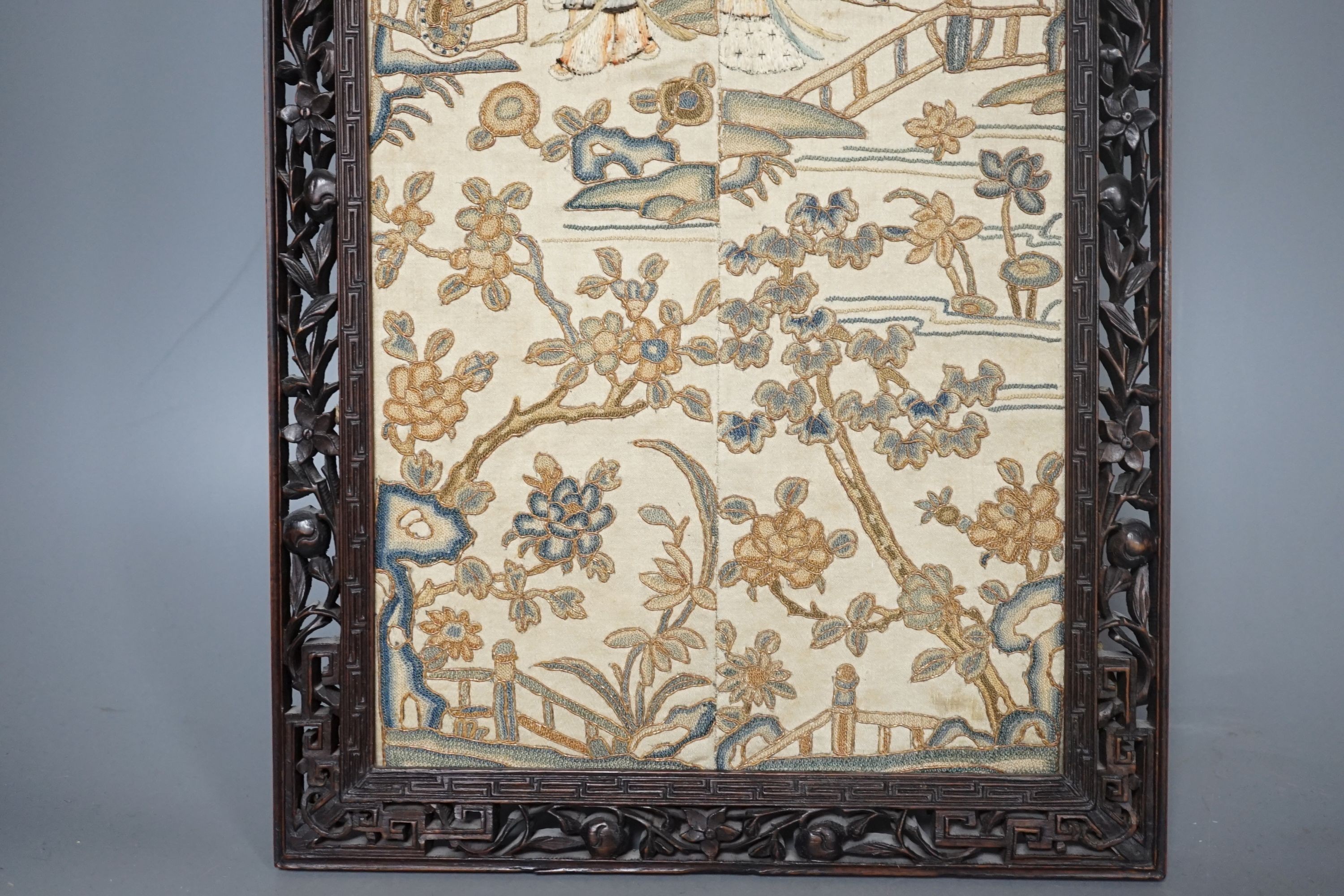 A pair of Chinese silk Beijing knot embroidered sleeve bands in a carved rosewood frame, 22 cms wide x 58.5 cms high, including frame.